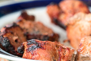 Pieces of kebab removed from skewers and put on a plate.