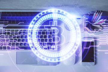 Blockchain theme hologram drawings over computer on the desktop background. Top view. Multi...