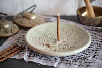 Tibetische Räucherstäbchen auf rundem Halter Yggdrasil mit Zimbeln (Close-up)