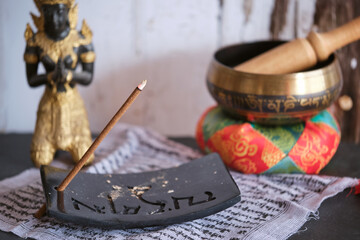 Tibetische Räucherstäbchen auf schwarzem Specksteinhalter mit Tempelfigur und Klangschale