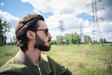 A handsome man in a sunglasses is standing outdoors.