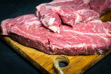 Raw marbled beef steak. Close-up photo on dark background.