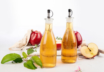 Apple cider vinegar and fresh apples on light background. Healthy organic food.