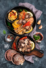 Grilled seafood variety with vegetables on dark background.