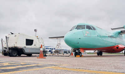 Naklejka premium Vehicle nearby. Turboprop aircraft parked on the runway at daytime