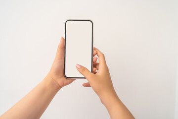 Closeup shot of a woman typing on mobile phone isolated on white background.. Girl's hand holding a...