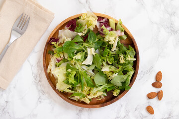 Salad menu on wooden plate and almonds