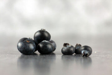 a pile of blueberry against gray background extreme close up