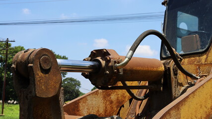 Old hydraulic cylinders and pistons. Hydraulic systems with bolts and oil hoses for loaders or...