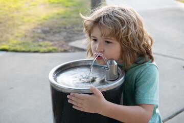 Refreshment solution. Thirsty kid drink water from drinking fountain. Thirst quenching