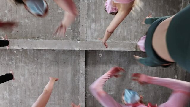 Group or team of happy young sportive women in a gym all cheering with elbows and applauding, all wearing facemasks to protect for coronavirus or covid. High quality FullHD footage