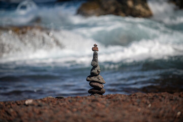 Stones pyramid on pebble beach symbolizing stability, zen, harmony, balance.