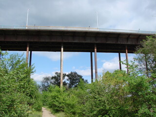 Bottom view of the power and grandeur of the arch bridge against the background of heavy gray clouds.