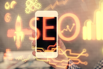 Multi exposure of man's hands holding and using a digital device and seo drawing. search...