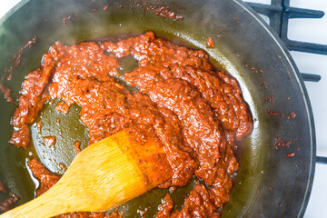 Cooking tomato sauce in a frying pan.