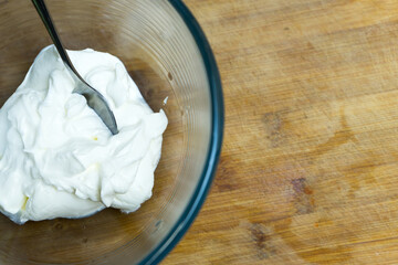 Natural sour cream in a glass plate.