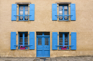 Fototapeta na wymiar La maison aux yeux bleus, une porte et quatre fenêtres