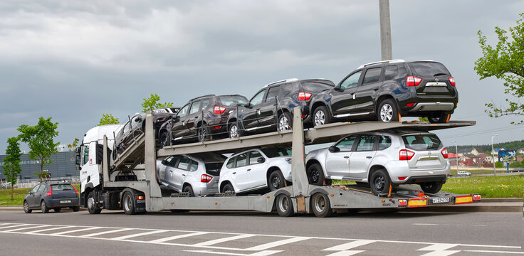 Minsk, Belarus. May 2021. Car carrier hauls new cars Nissan Terrano. Car transporter with new Nissan cars parked at roadside. New cars transportation, delivery to dealership.