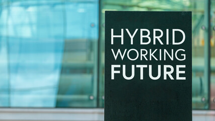 Hybrid Working Future on a sign outside a modern glass office building	
