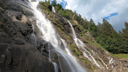 Naklejka na ściany i meble Beautiful summer mountain forest waterfall