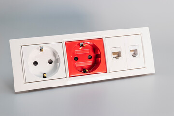 A block of electrical outlets and a network outlet on a gray background. Home electrician....