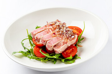 tuna fillet with salad on white plate