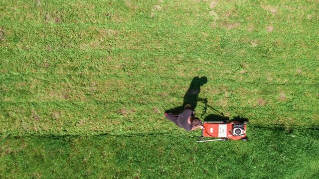 Aerial view of caucasian man mowing lawn time lapse