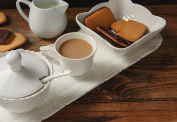 Coffee cup and cookies on a tray on wooden table