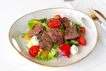 Fillet of beef with vegetable salad on wooden table