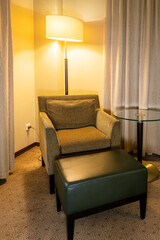 floor lamp shines and an easy chair for relaxing in the hotel room