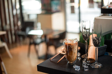 Close-up of iced coffee served on black table at cafe​