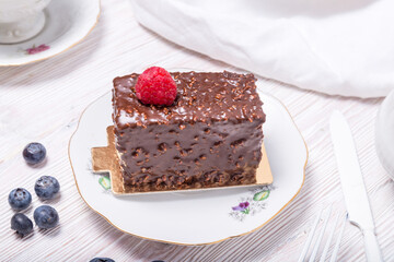 Piece of berry cake decorated with fresh berries on wooden background