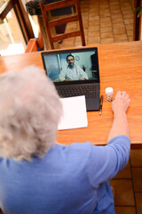 elderly senior woman, having a remote medical consultation with her doctor over internet and laptop computer telemedecine diagnostic.