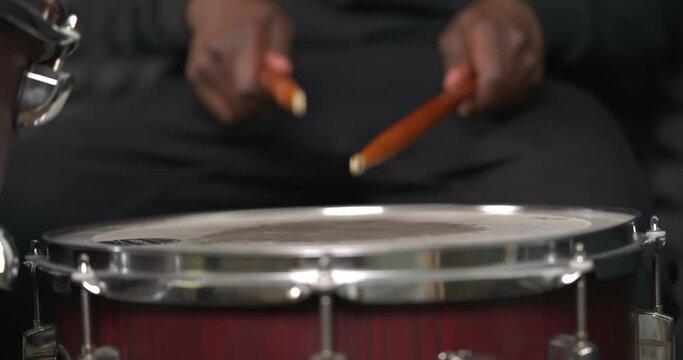 African man's hands hits the drum. Drummer performing solo with drumsticks. Percussion musical instrument.