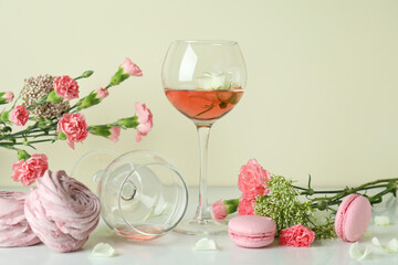Wine, sweet food and flowers on white table