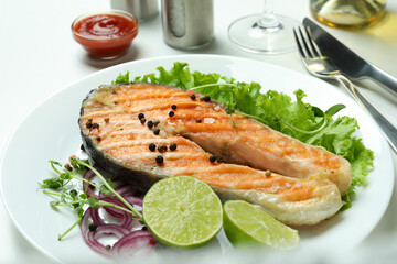 Concept of tasty eating with grilled salmon on white background