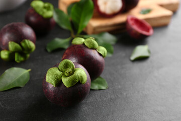 Fresh ripe mangosteen fruits on dark grey table