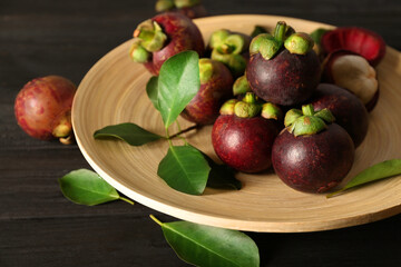 Fresh ripe mangosteen fruits on dark wooden table