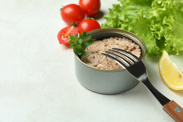 Concept of tasty eating with canned tuna on white textured background