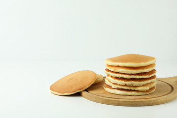 Board with tasty pancakes on white table
