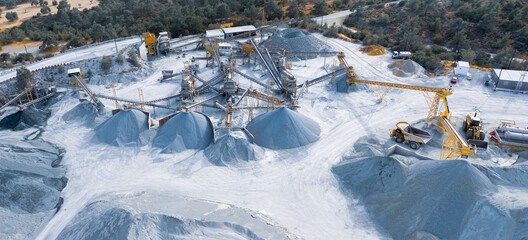 Aerial panorama of stone crushing and screening plant with piles of gravel and machinery in Pyrga,...