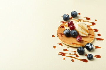 Concept of tasty food with pancake on beige background