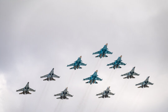 Moscow, Russia - May, 05, 2021: Fighters Su-35S and Su-30SM with bombers Su-34 in the blue sky over Red Square in the group Tactical Wing. Aviation part of Victory parade in Moscow