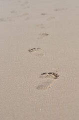 foot steeps in the surface of sand beach