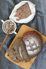 FlFlat lay composition with bowl of buckwheat flour, grains and bread on grey table