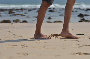 male foots or feet running gesture in the beach with blurred sea background