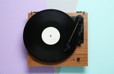 Fototapeta premium Turntable with vinyl record on color background, top view