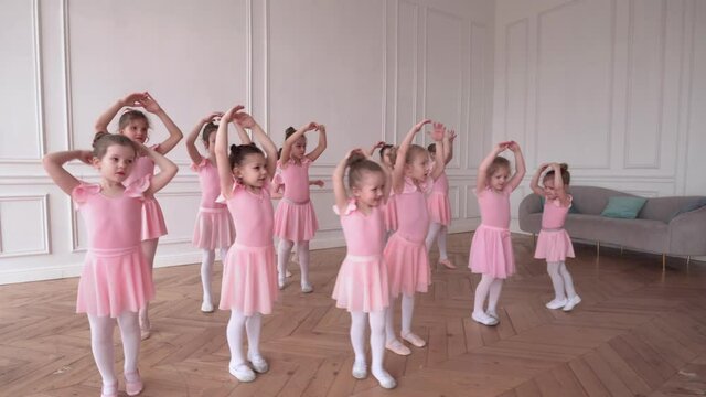 Girls dancers in ballet school learns to dance. Little Ballerinas in training in pink dancing suit. Children's ballet school. School of ballet.
