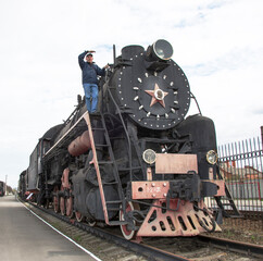 Obraz premium The machinist of a steam locomotive looks afar