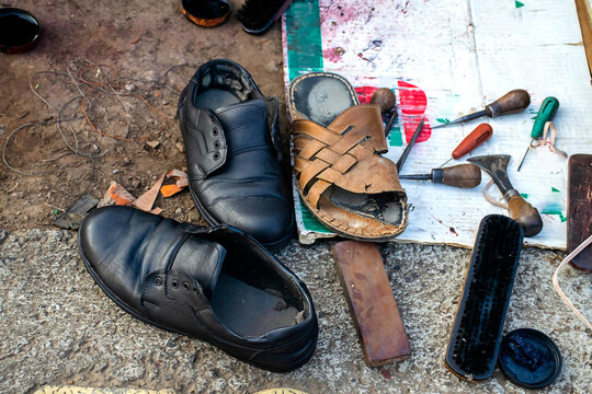 Stock photo of local Indian cobbler shop or shoe repair shop. There are number of shoe repair tool like leather, thread, cutter, brush, stand etc. Picture captured at Kolhapur Maharashtra India.